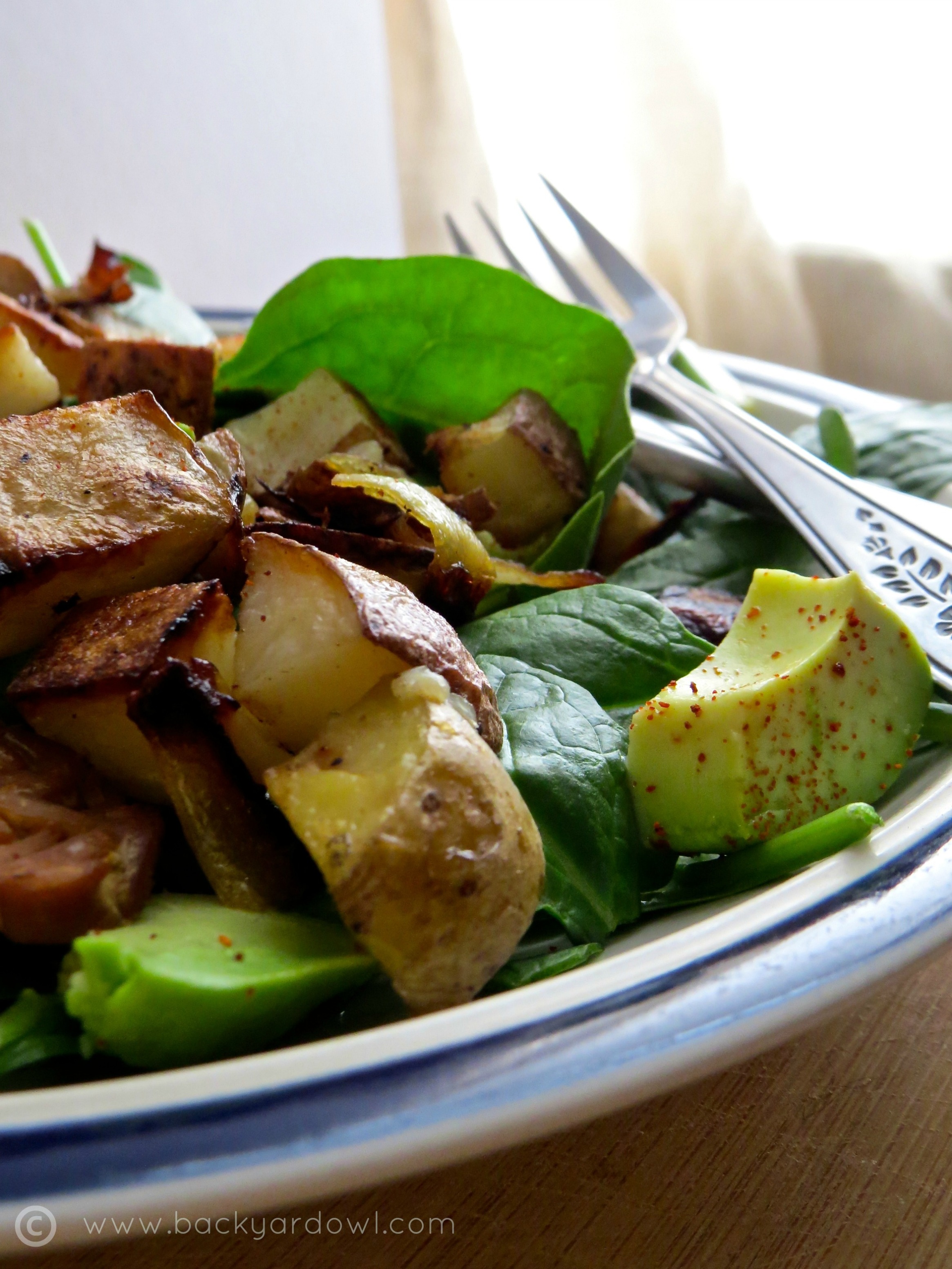 spinach salad with tempeh, avocado, and roast potatoes